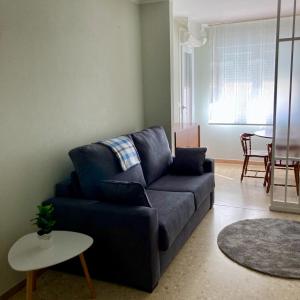 a living room with a blue couch and a table at Apartamentos Angelito in Playa América