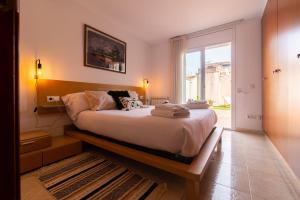 a bedroom with a large bed and a large window at Apartamento con gran patio y excelente ubicación! in Mataró