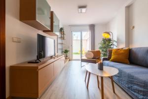 sala de estar con sofá azul y TV en Apartamento con gran patio y excelente ubicación!, en Mataró