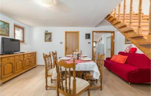 sala de estar con mesa y sofá rojo en Lovely Home In Bricanci With Kitchen, en Svetvinčenat