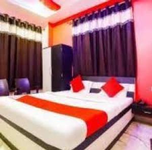 a bedroom with a large bed with red pillows at Hotel Vinayak Vihar, Sasaram in Ara