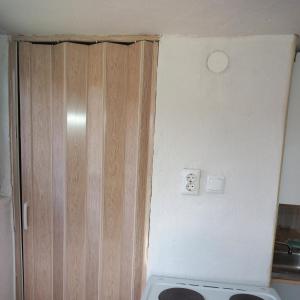 una cocina con una puerta de madera junto a una estufa en Kuca za odmor-P-, en Visoko