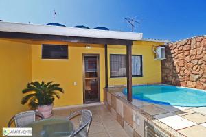 une maison jaune avec une piscine sur une terrasse dans l'établissement Cobertura duplex 2 quartos com terraço e piscina, à Rio de Janeiro