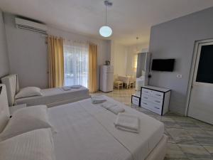 a large bedroom with two beds and a television at Hotel Artur2 in Ksamil