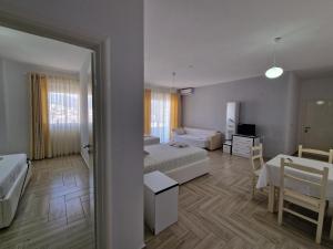 a bedroom with two beds and a table and a room at Hotel Artur2 in Ksamil