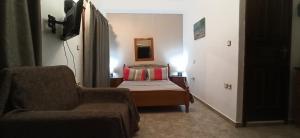 um pequeno quarto com uma cama e uma cadeira em Villa Maria em Kalymnos