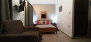 a small bedroom with a bed and a chair at Villa Maria in Kalymnos +47 photos