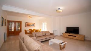a living room with a couch and a flat screen tv at Amora Classic Villa in Vilamoura
