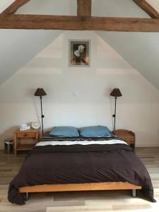 - une chambre avec un lit doté d'oreillers bleus et de 2 lampes dans l'établissement Charmant gîte avec poêle à bois, à Pleslin-Trigavou