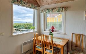 een eetkamer met een tafel en twee ramen bij Awesome Home In Habo With House Sea View in Habo