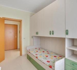 1 dormitorio con 1 cama en una habitación con armarios blancos en L'orchidea appartamento in Puglia, en Sammichele di Bari