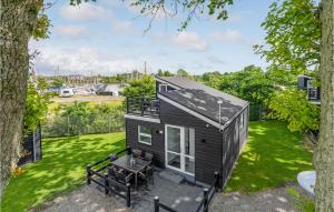einen Ausblick auf ein kleines schwarzes, winziges Haus auf einem Rasen in der Unterkunft Amazing Home In Assens With House Sea View in Assens