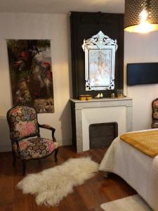 - un salon avec une chaise et une cheminée dans l'établissement Chez Janine, à Saint-Laurent-dʼAigouze