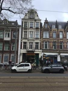 two cars are parked in front of a building at Frank’s and Chong’s excellent location in Amsterdam