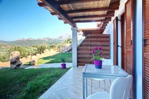 patio con mesa, sillas y vistas en Sardinia Green Park Country Lodge, en Olbia
