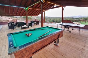 a pool table in a pavilion with two tables at Sardinia Green Park Country Lodge in Olbia