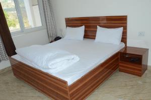 un grande letto con struttura in legno in una stanza di Shivalik Riverine Homestay and hotel a Lansdowne