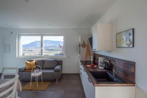 a kitchen and living room with a couch and a sink at Pia´s Bleibe in Caldaro