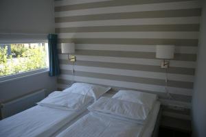 two beds in a room with a striped wall at Camping Hotel Renesse in Renesse