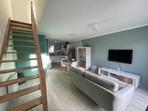 salon z kanapą i schodami w obiekcie Charmant gîte au cœur des huttes, proche de la mer w mieście Gravelines
