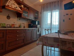 a kitchen with a table and a white refrigerator at Stanza Singola - Certosa in Milan