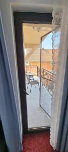 a door to a balcony with a view of a table at RIA Room - Apartemente 9 in Baile Felix
