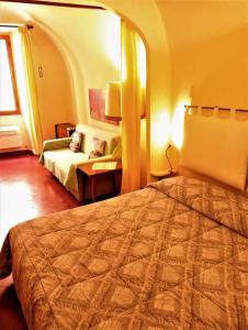 シエナにあるcasa Beccheriaのベッドとソファ付きのホテルルーム
