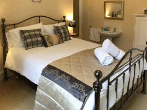 1 dormitorio con cama grande con almohadas y lavamanos en Karslake House en Winsford