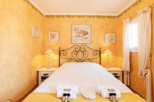 1 dormitorio con 1 cama grande y 2 mesitas de noche en Maison De Poupée YourHostHelper, en Tourrettes