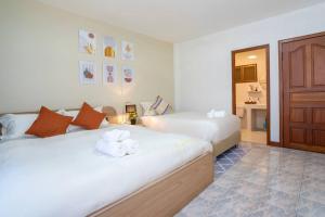 pokój hotelowy z 2 łóżkami i ręcznikami w obiekcie Solene Home Patong w Patong Beach
