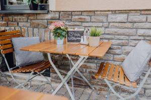 una mesa de madera con 2 sillas y flores. en Pascals Ruhestube en Mörsdorf