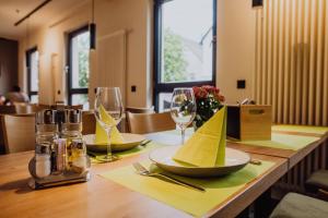 a wooden table with wine glasses and a yellow napkin at Pascals Ruhestube in Mörsdorf