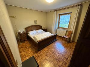 a bedroom with a bed and a table and a window at Baita del Canton in Valdidentro