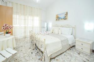 a white bedroom with a bed and a table at B&B SOGNI D'ORO in Reggio di Calabria