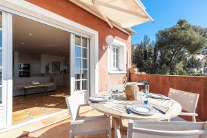 a patio with a table and chairs on a deck at Le Golfe Bleu - Havre de paix en bord de plage in Roquebrune-Cap-Martin