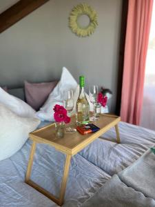 サウルクラスティにあるHouse of Inspirationのベッドの上にワインボトルとグラスを用意したテーブル