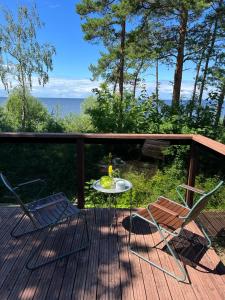 two chairs and a table on a deck with a view of the ocean at House of Inspiration in Saulkrasti