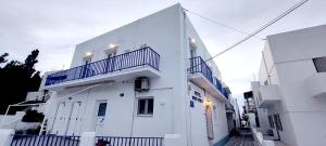 un edificio blanco con un balcón en el lateral. en Kato Yialos Paros en Parikia