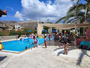 a group of children playing in a pool at a resort at Villa Maria in Kalymnos