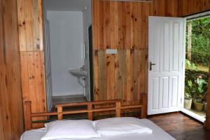 Solitude Munnar في مونار: غرفة نوم بسرير وحمام مع حوض
