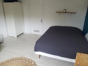 een slaapkamer met een bed en een houten tafel bij Studio confort chez Lolita et Wilfried in Saint-Laurent-sur-Sèvre