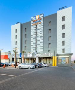 塞卡凱的住宿－Ewaa Express Hotel - Al Jouf，停车场内有车辆的旅馆