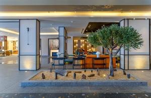 Un vestíbulo con un árbol en el medio. en Ewaa Express Hotel - Al Jouf en Sakaka