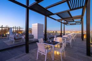 eine Terrasse mit Tischen und Stühlen auf dem Dach in der Unterkunft Ewaa Express Hotel - Al Jouf in Sakaka