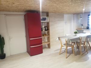 a kitchen with a red cabinet and a table and chairs at Studio confort chez Lolita et Wilfried in Saint-Laurent-sur-Sèvre