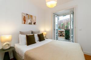 a bedroom with a large bed and a patio at Gonzalos's Guest Apartments - Alfama Terrace in Lisbon