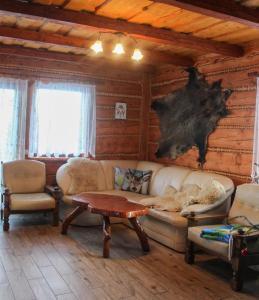 sala de estar con sofá, sillas y mesa en Domek u Johnnego 27, 