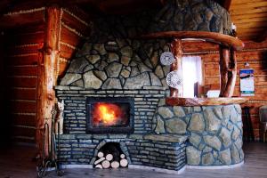 a fireplace in a log cabin with a fire in it at Domek u Johnnego 27 in Piwniczna-Zdroj +30 photos