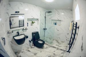 uma casa de banho com um WC, um lavatório e um chuveiro em Villa Belle in Tashkent City em Tashkent