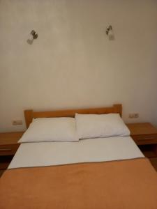 una camera da letto con un letto con due cuscini sopra di Žulj Vodice a Vodice